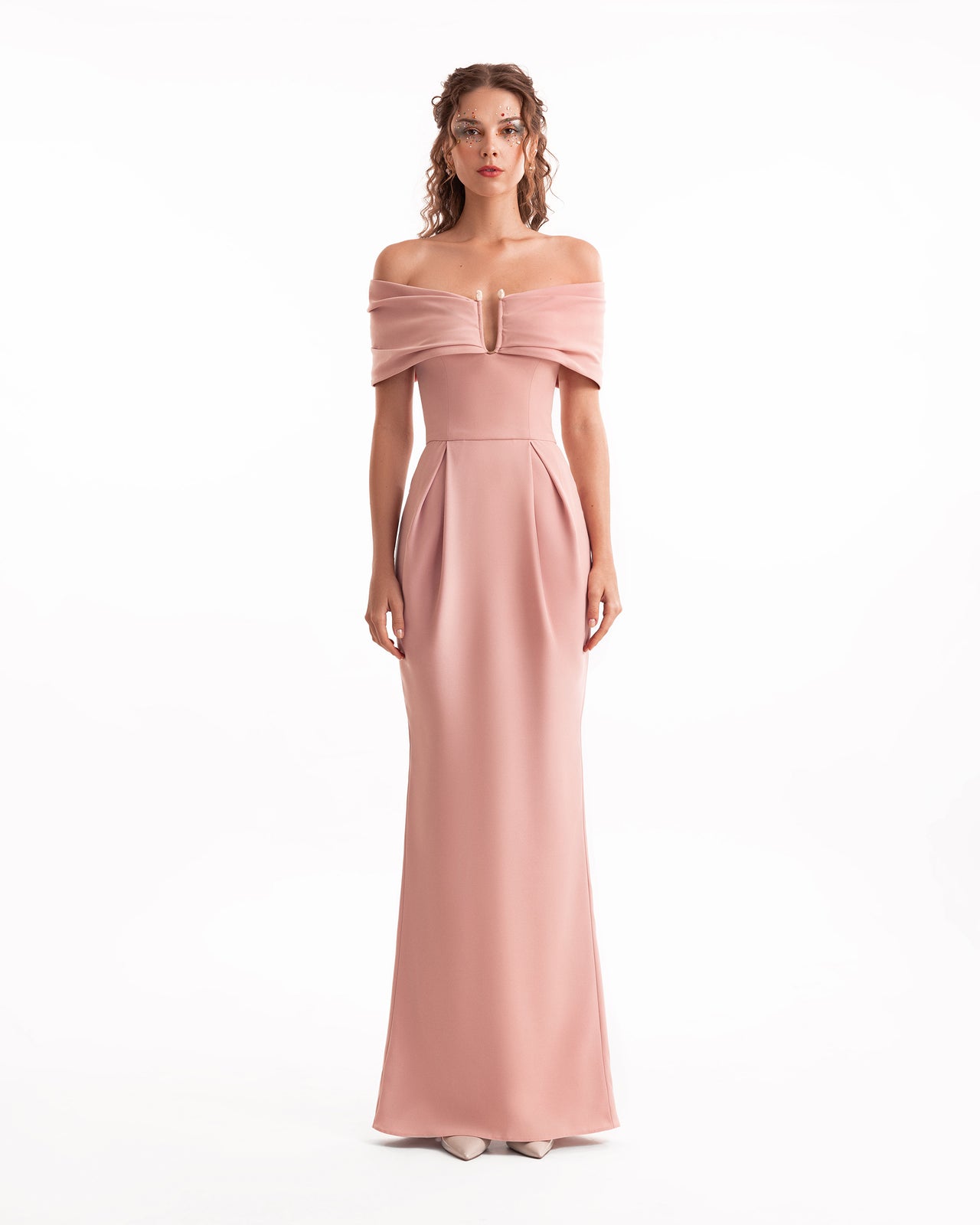 Woman wearing a pink off-shoulder gown on a white background
