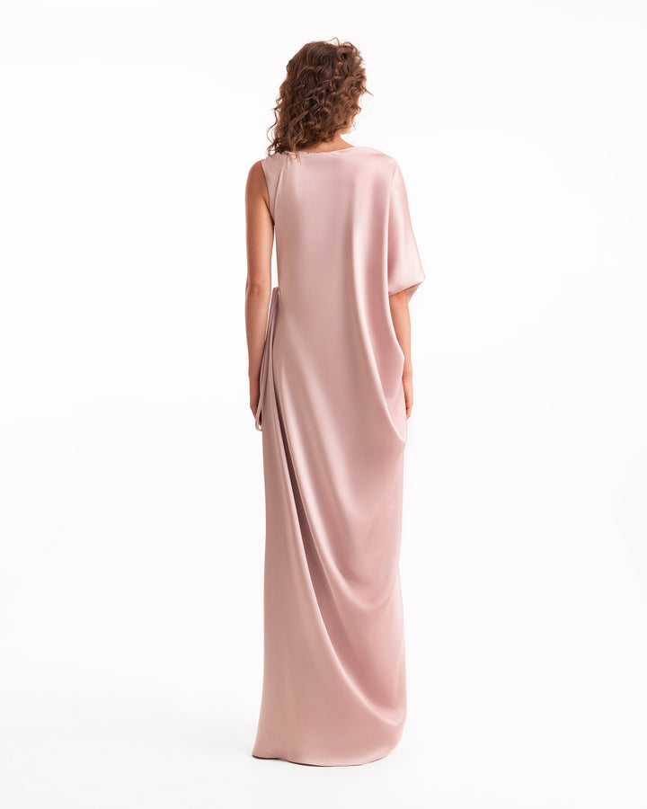 Woman wearing a long, light pink dress on a white background