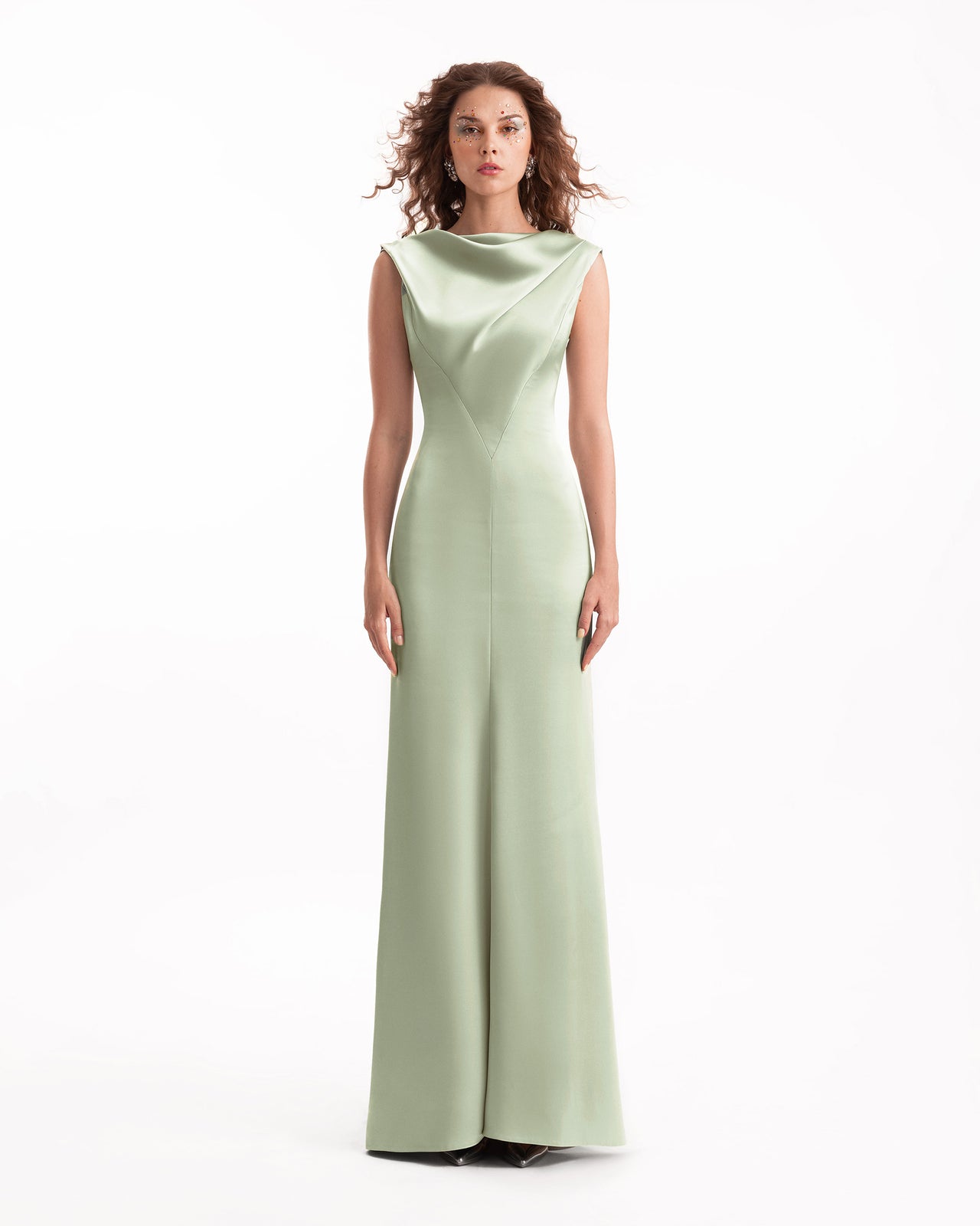 Woman wearing a light green evening gown on a white background