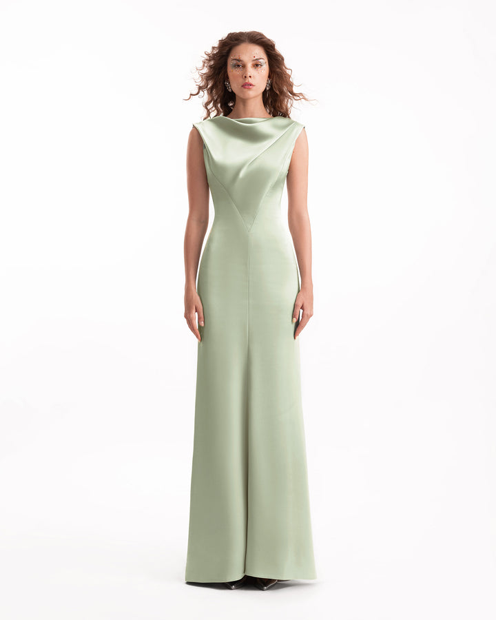 Woman wearing a light green evening gown on a white background