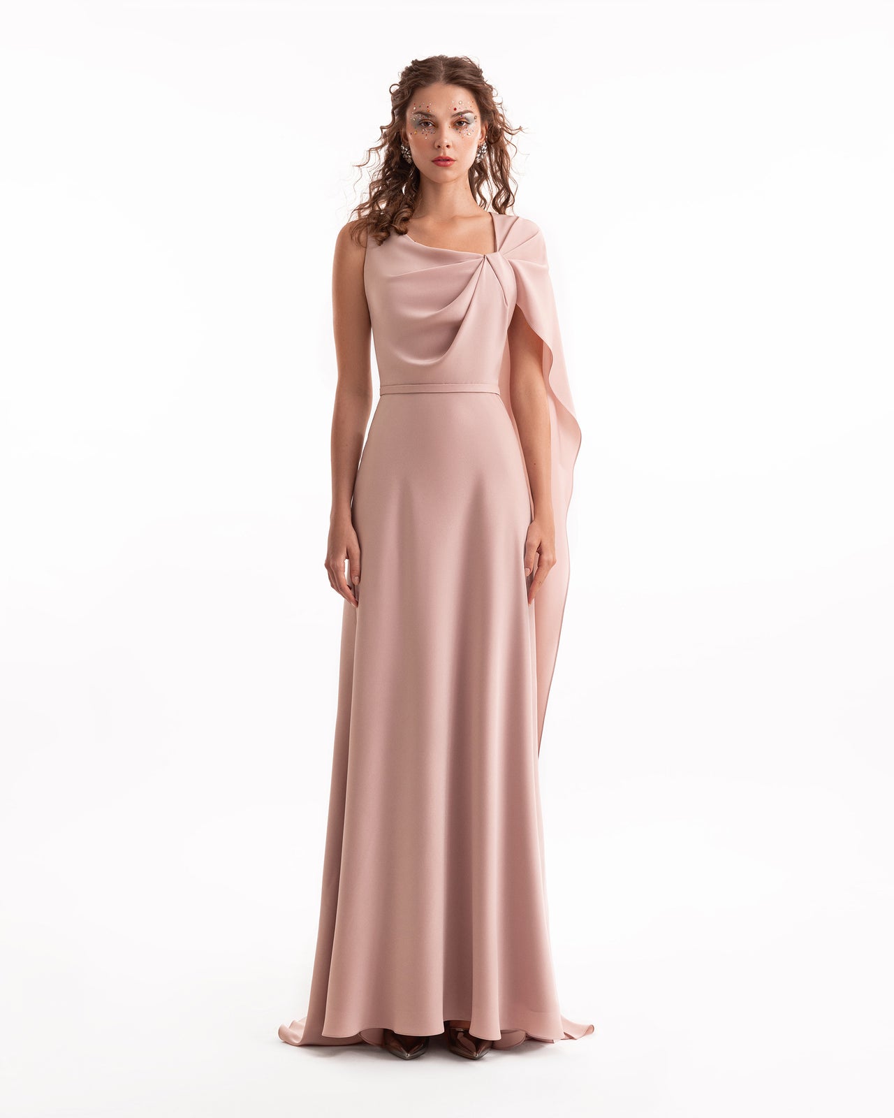 Woman wearing a long, elegant dress with a cape on a white background