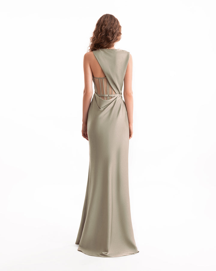 Woman wearing a long, one-shoulder dress with cut-out back on a white background