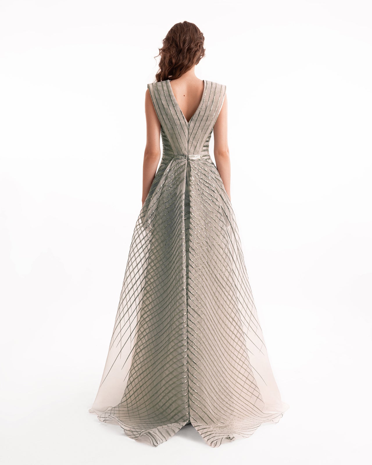 Woman wearing a long, patterned dress on a white background