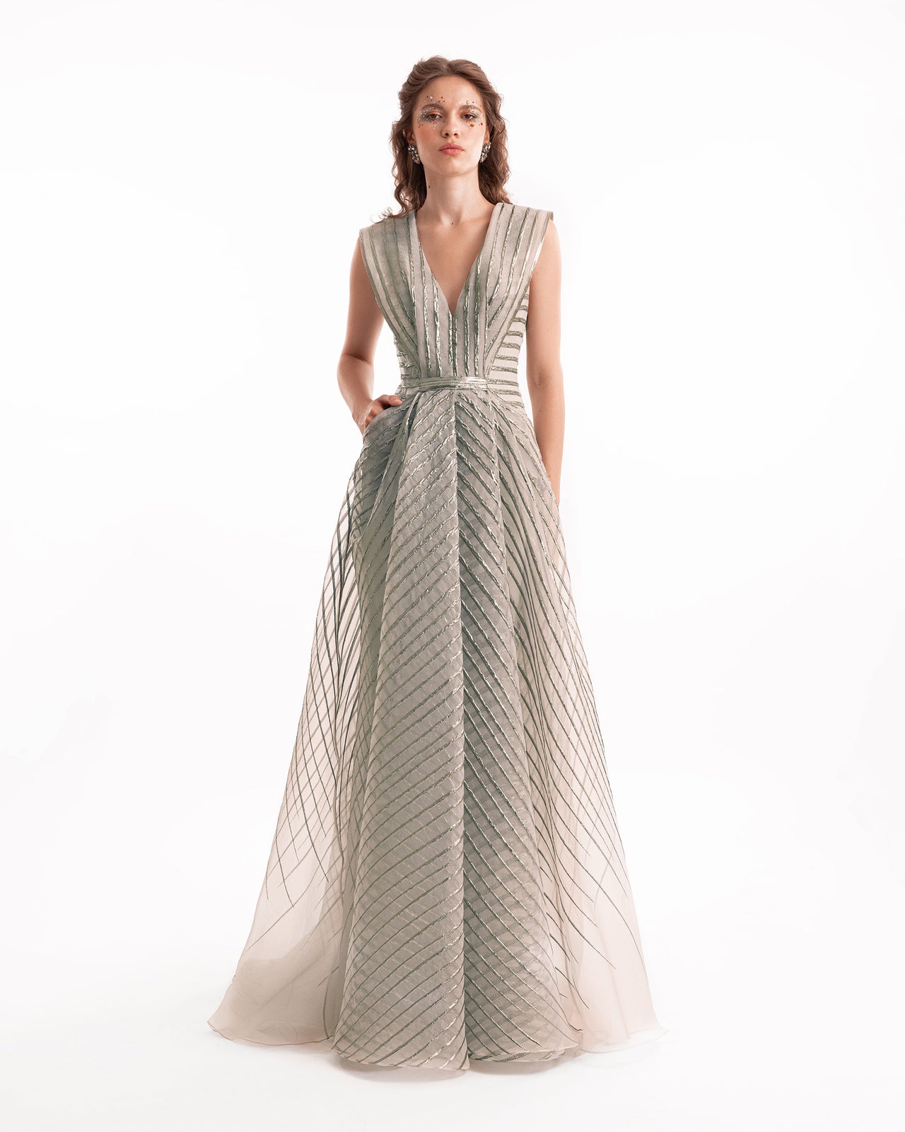 Woman wearing a long, patterned dress on a white background