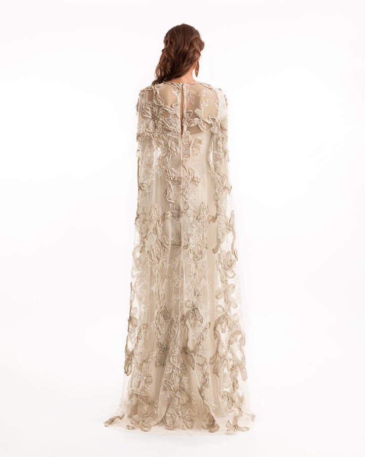 Woman wearing a long, floral lace dress on a white background