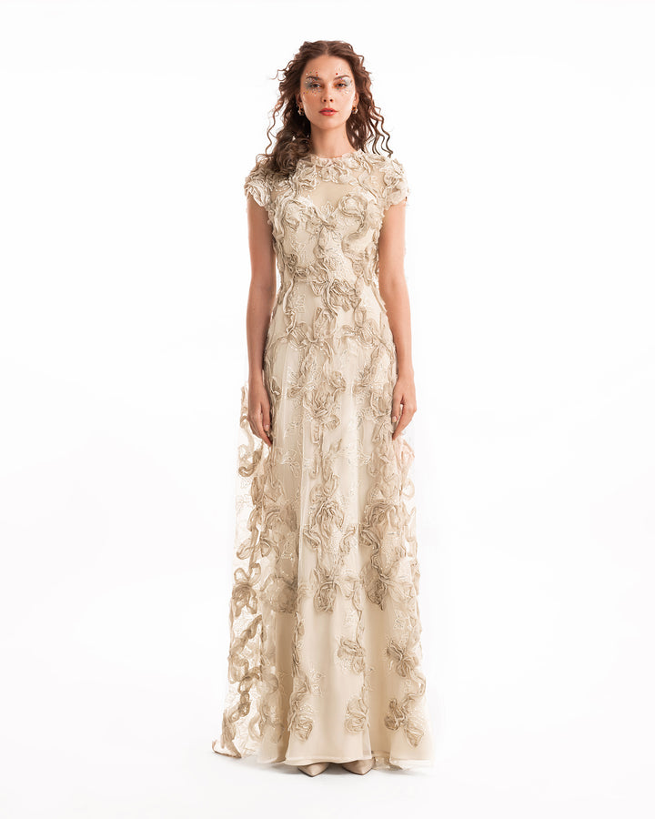 Woman wearing a long, floral lace dress on a white background