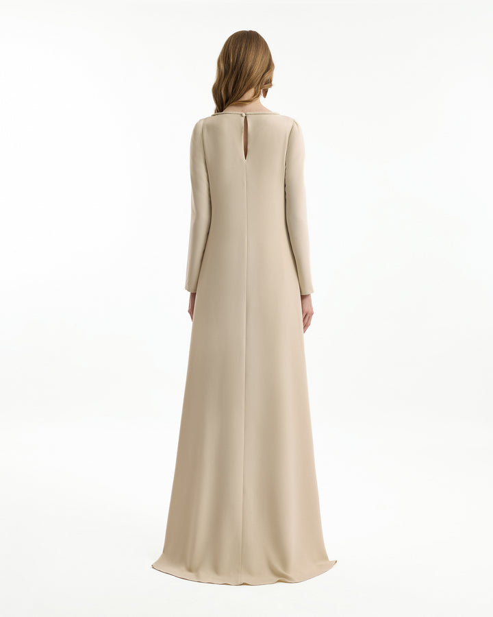 Beige long dress worn by a model on a white background