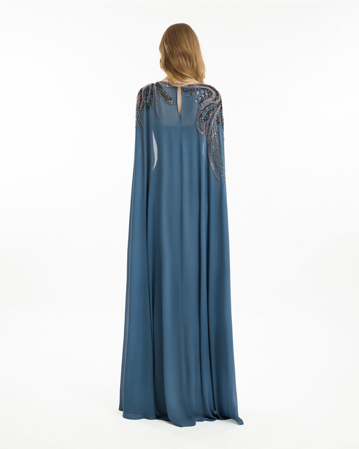 Long blue dress with intricate detailing on a white background