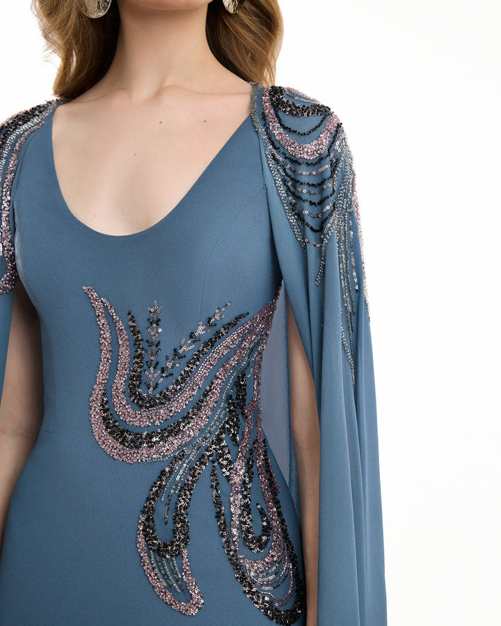 Blue dress with intricate beadwork on a white background