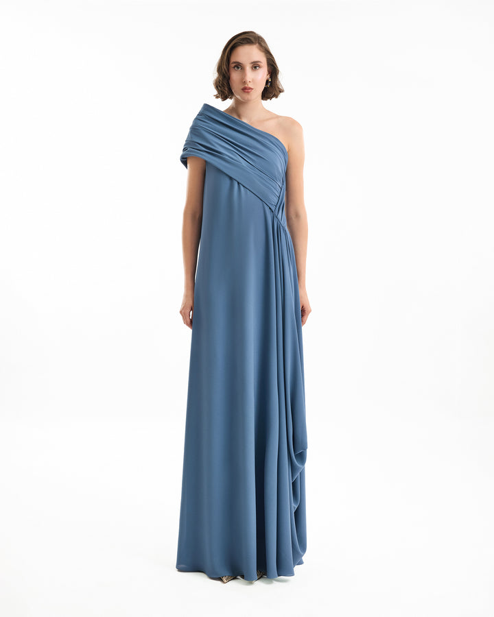 Woman wearing a blue one-shoulder gown on a white background