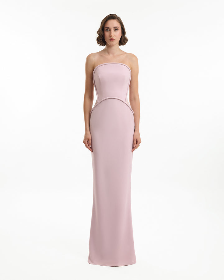 Woman wearing a strapless pink gown on a white background