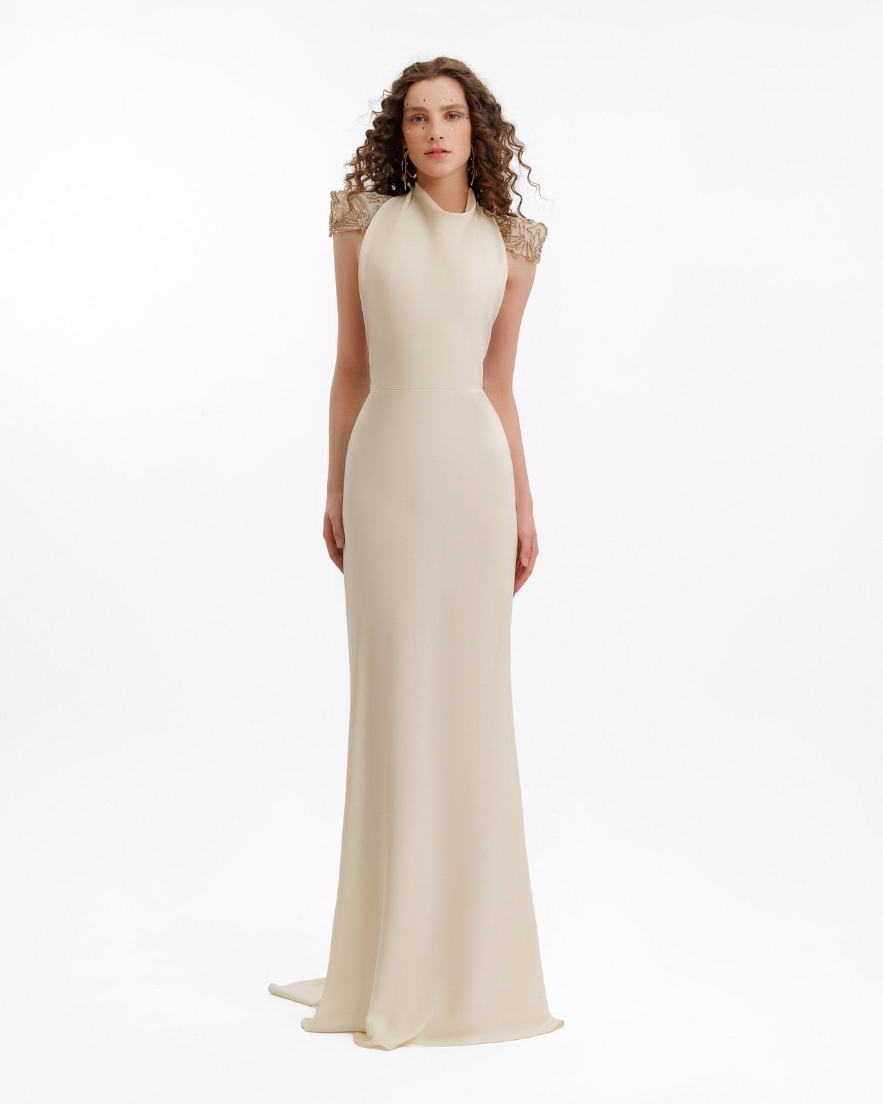 Elegant floor-length cream gown with a high neckline and gold embroidered shoulder details.