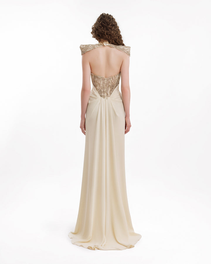 Woman wearing a beige evening gown with a lace bodice.