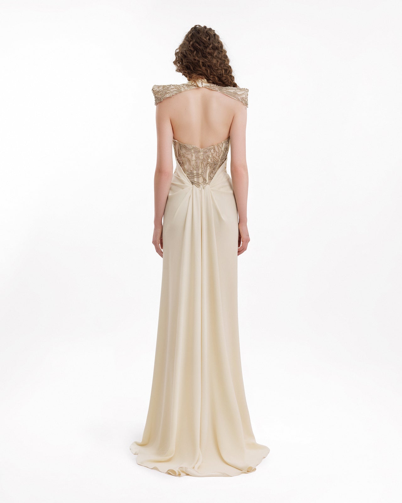 Woman wearing a beige evening gown with a lace bodice.