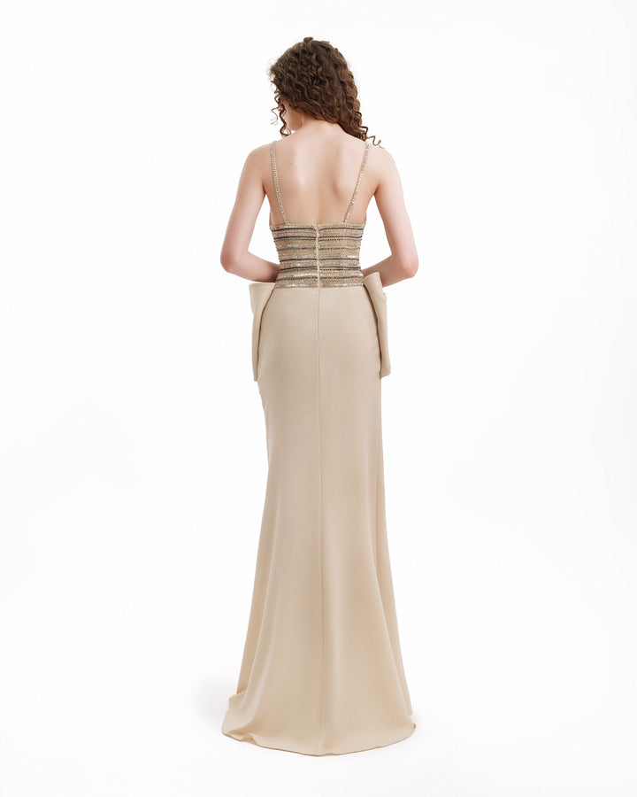 Beige evening gown with a fitted bodice and flowing skirt on a white background