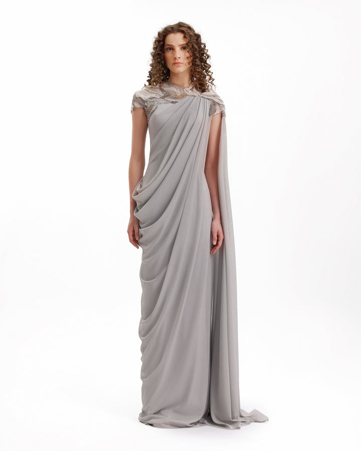 Woman wearing a gray draped gown on a white background