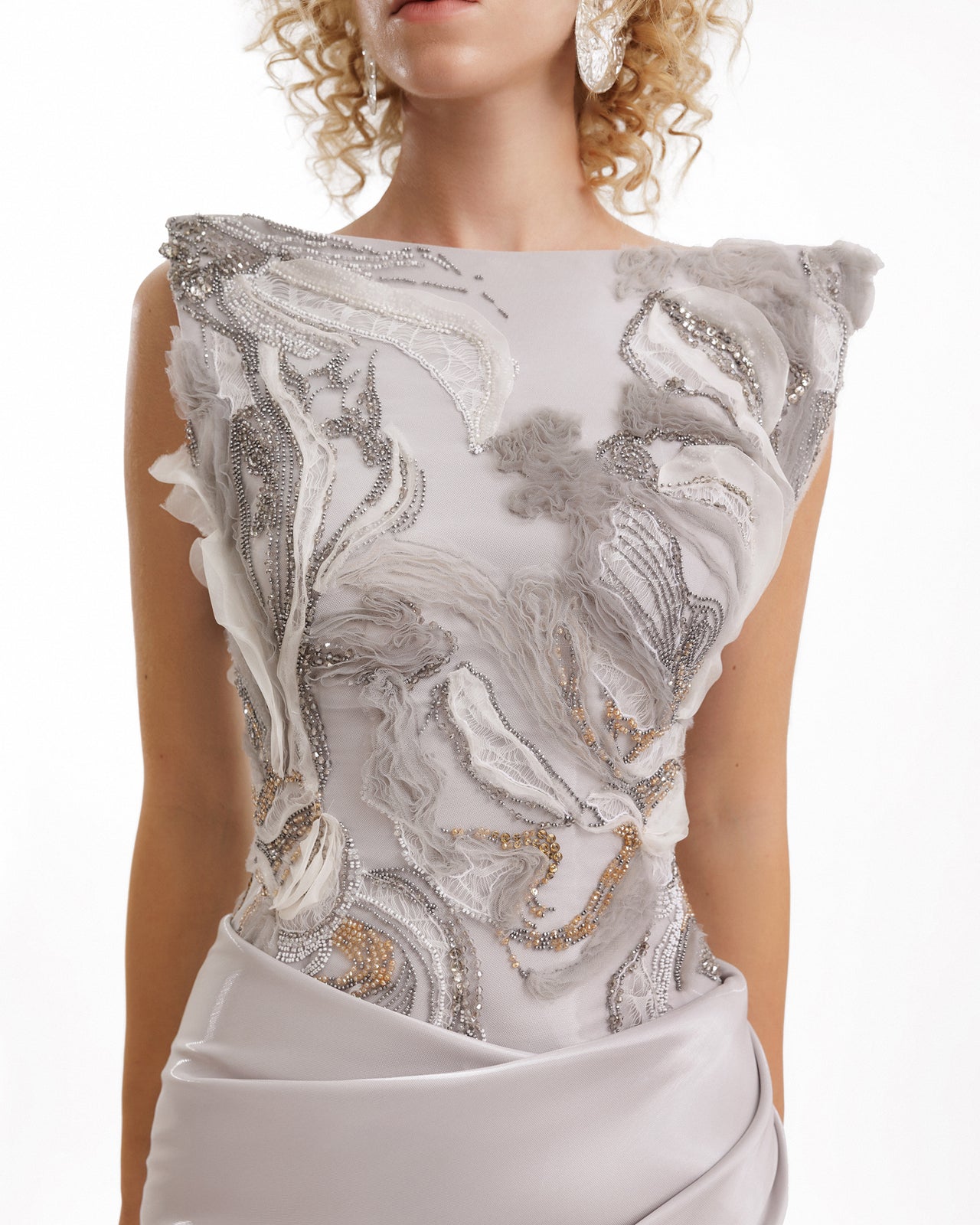 White dress with intricate silver and gold detailing on a white background