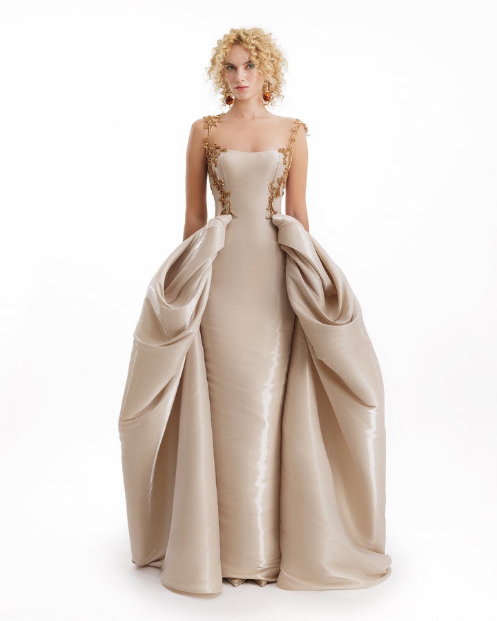 Beige evening gown with a large train on a white background