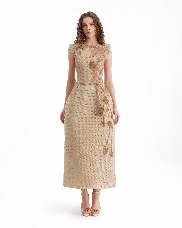 Woman wearing a beige dress with floral details on a white background