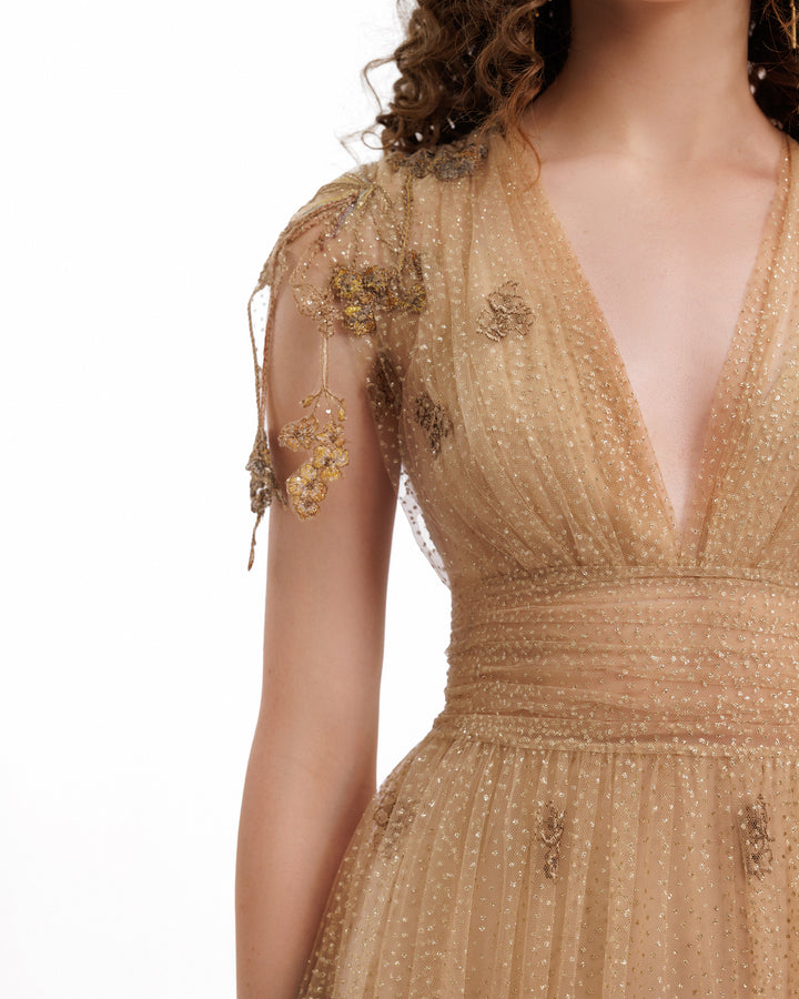 Gold embroidered dress with intricate detailing on a white background