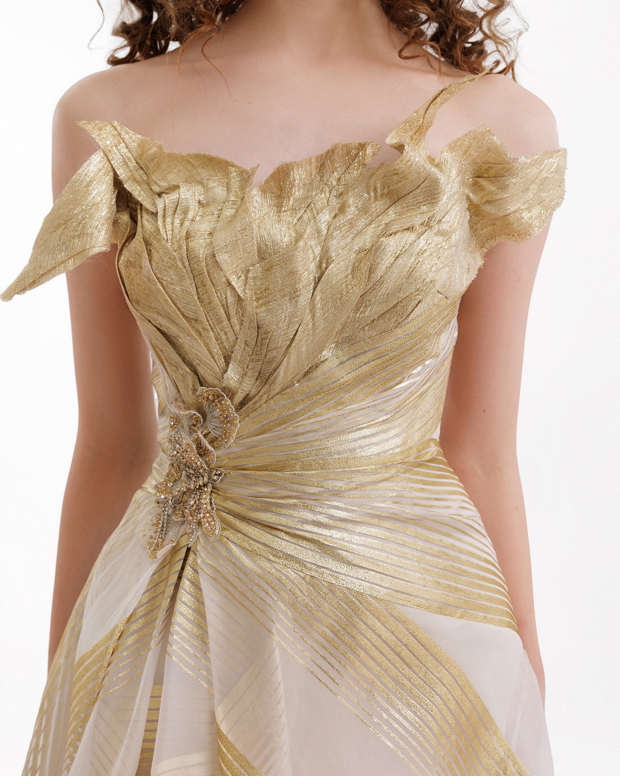 Gold evening gown with intricate design on a white background