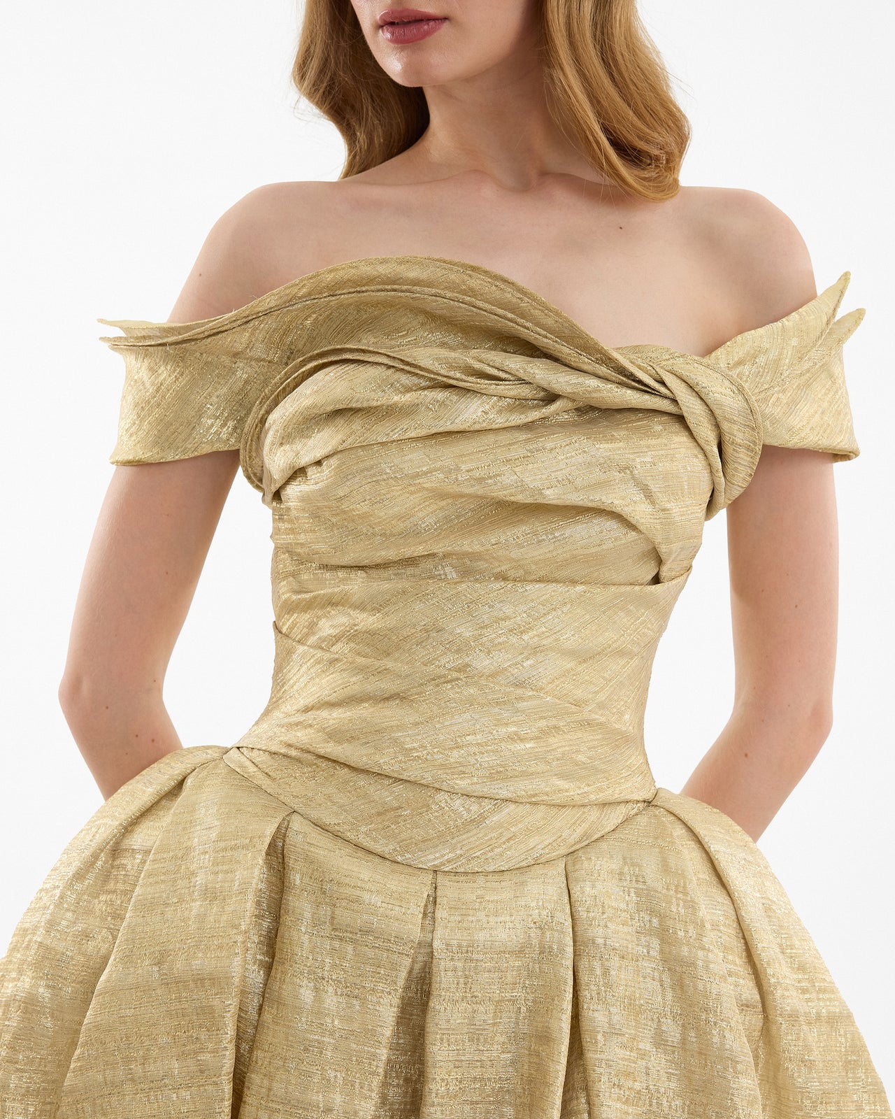 Gold off-shoulder dress with a bow detail on a white background