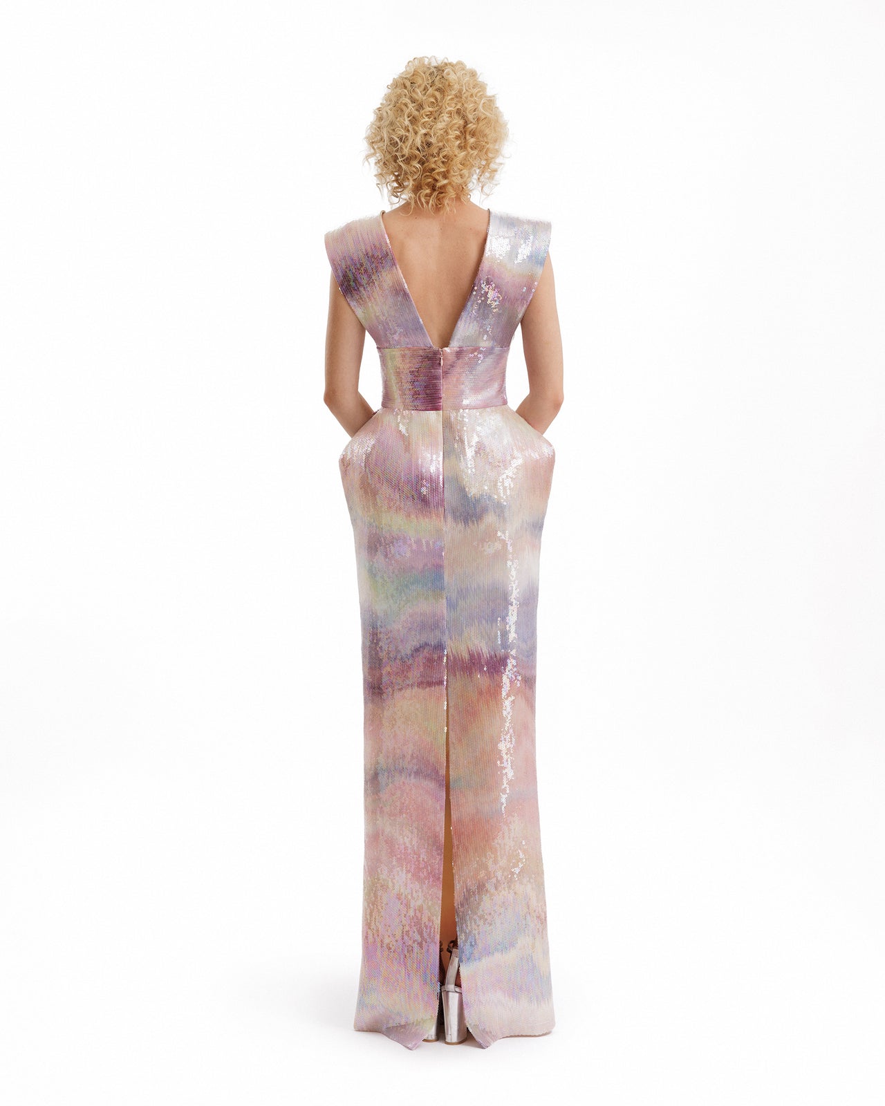 Woman wearing a colorful, sleeveless dress with a plunging neckline on a white background