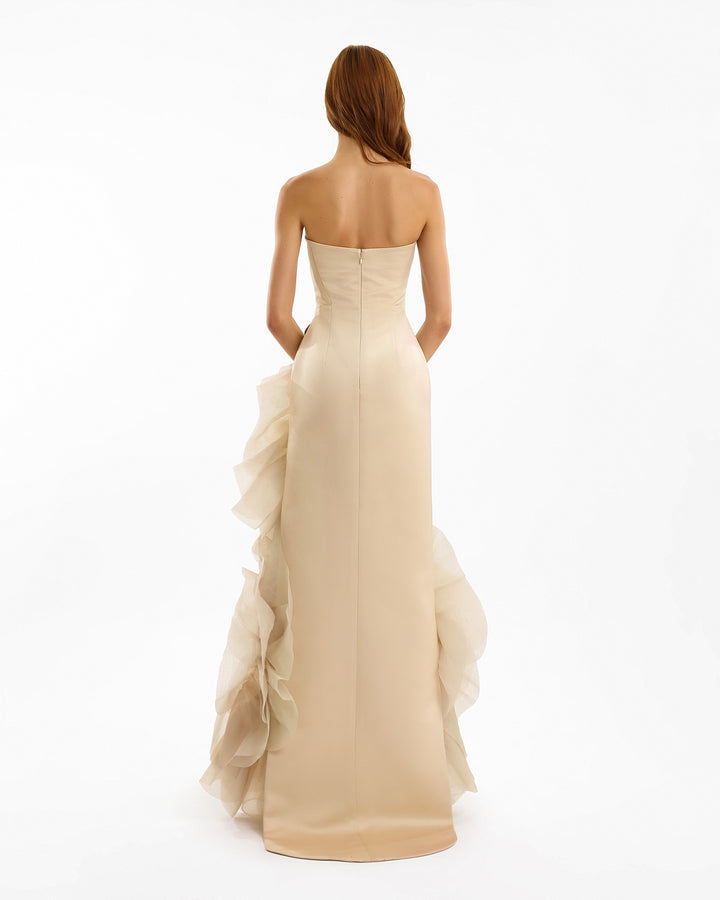 Beige strapless gown with ruffled skirt on a white background