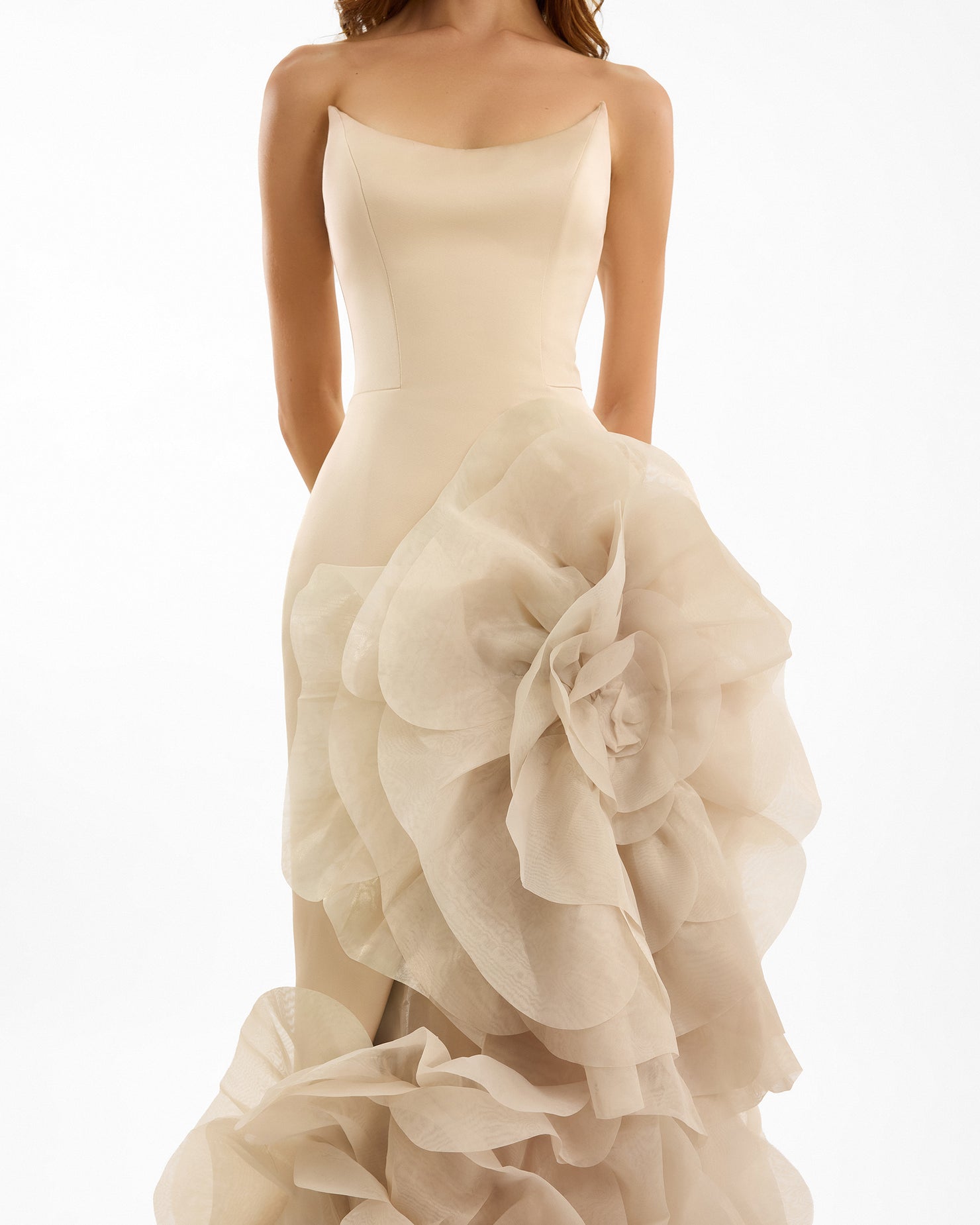 Beige strapless gown with ruffled layers on a white background