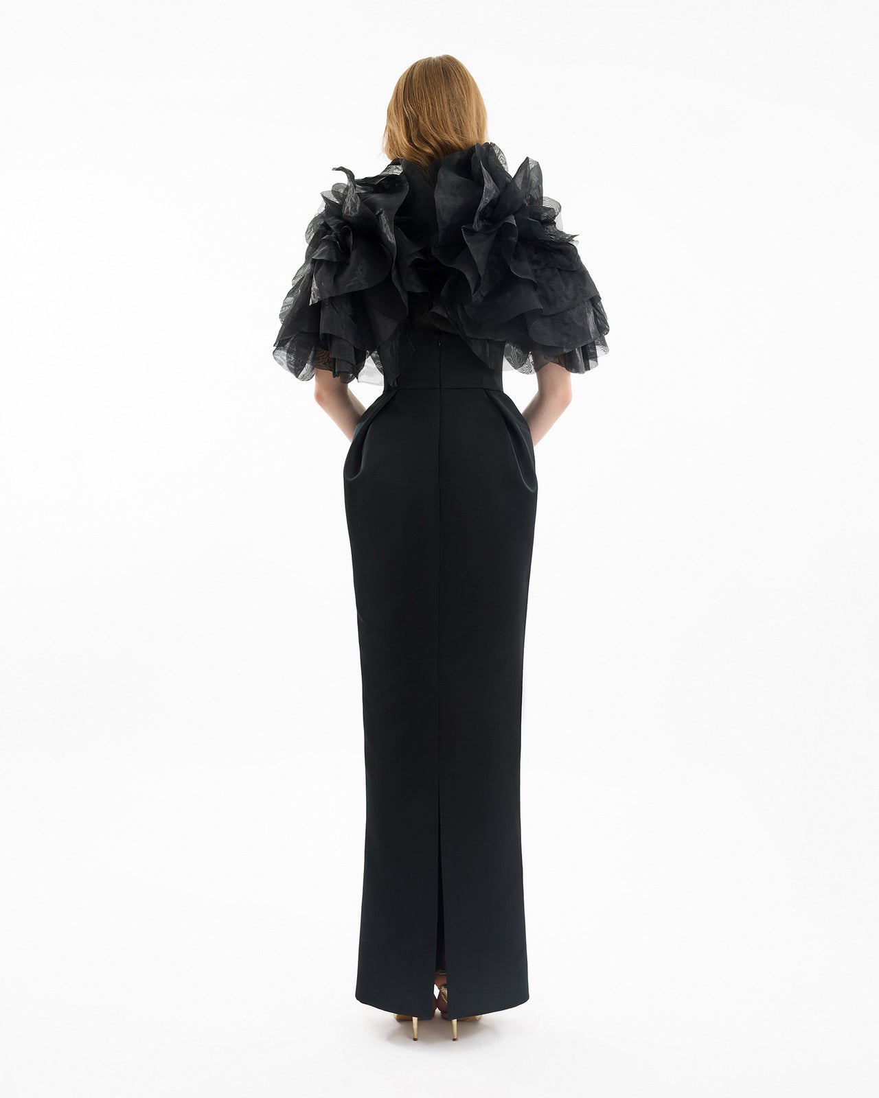 Black evening gown with ruffled cape on a white background