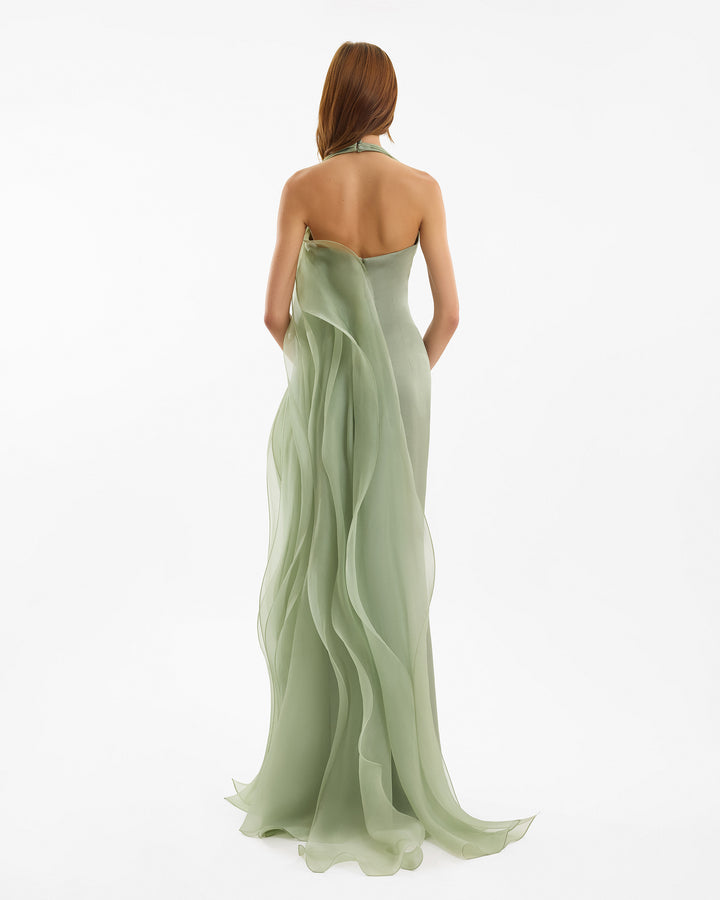 Woman wearing a light green strapless gown on a white background
