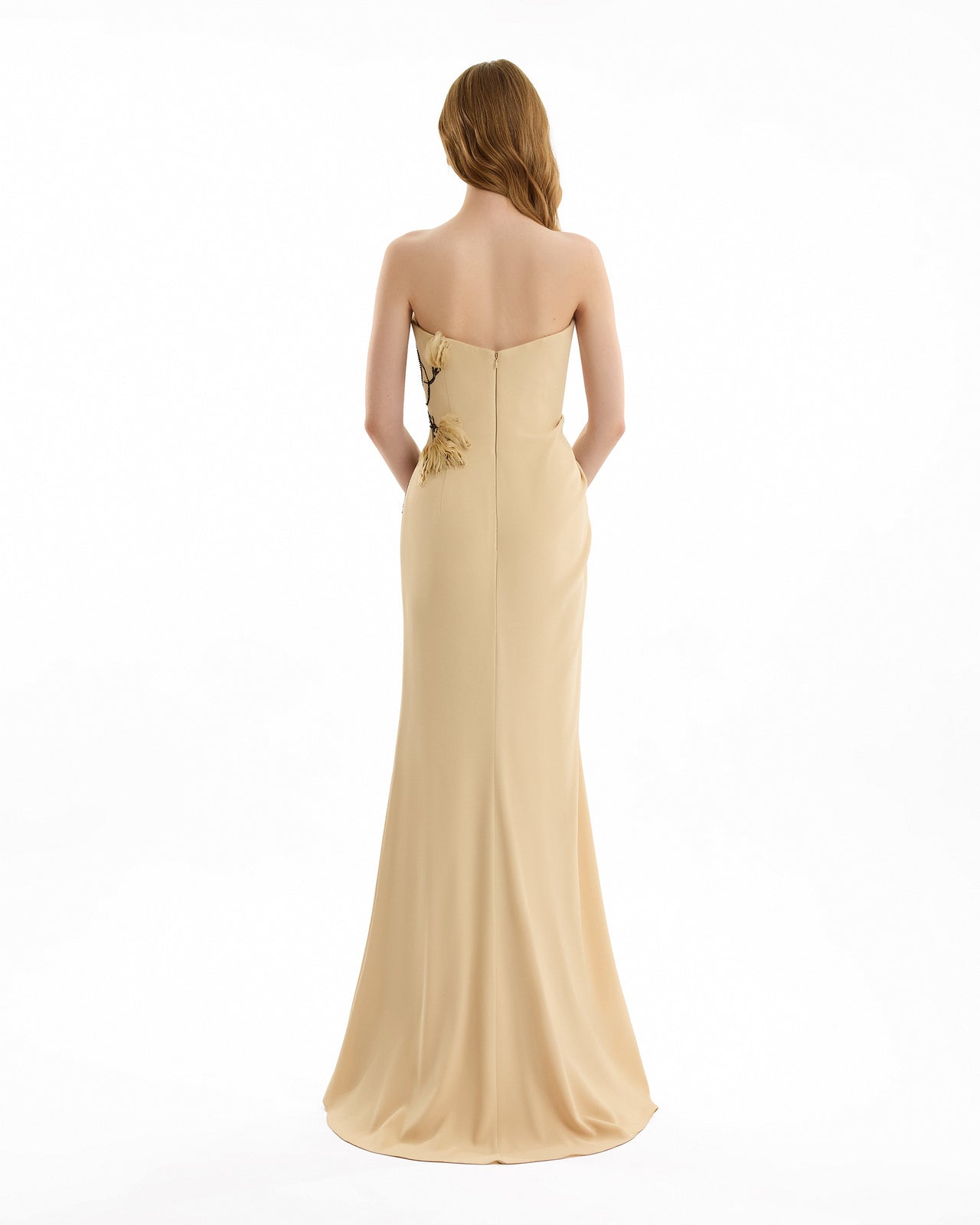 Beige strapless gown with floral detail on a white background
