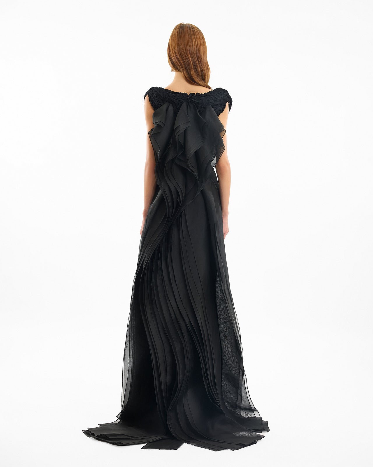 Black evening gown with a draped design on a white background