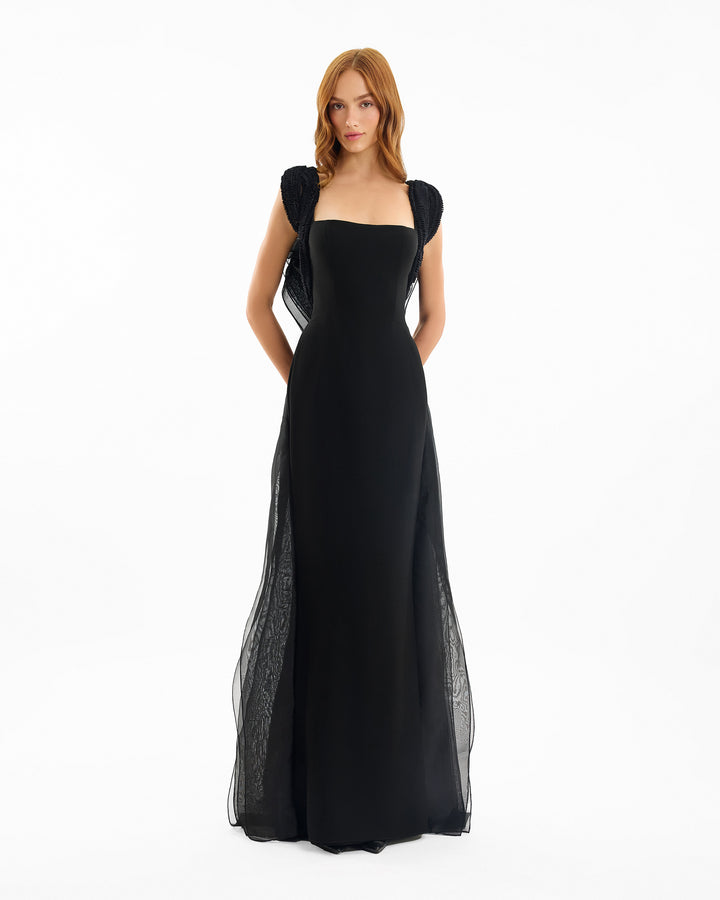 Black evening gown with sheer sleeves on a white background