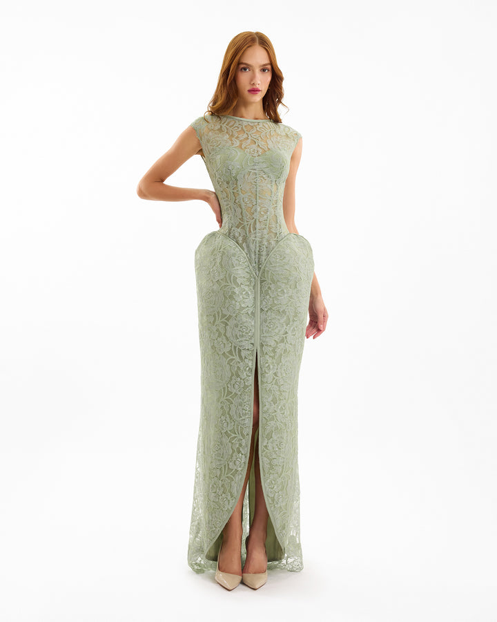 Woman wearing a green lace evening gown on a white background