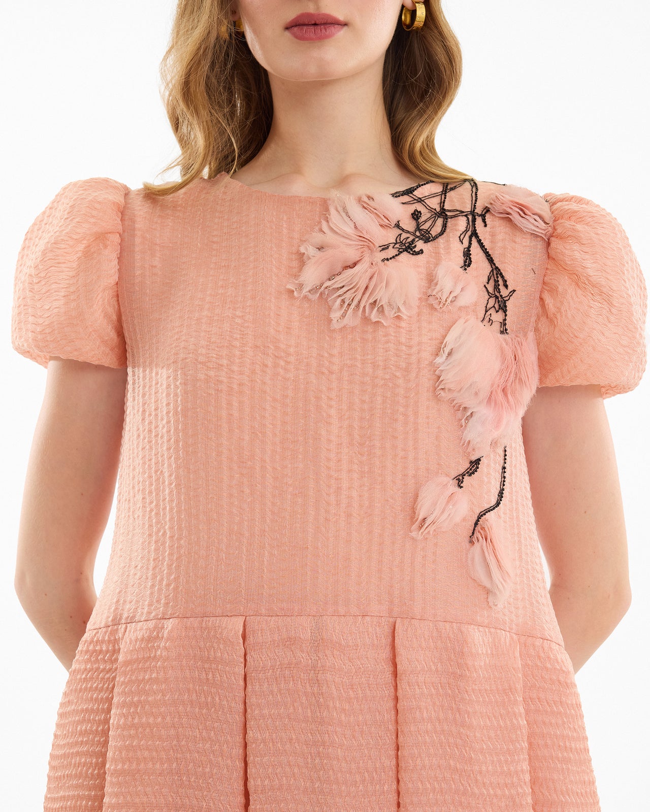 Pink dress with floral embroidery on a white background
