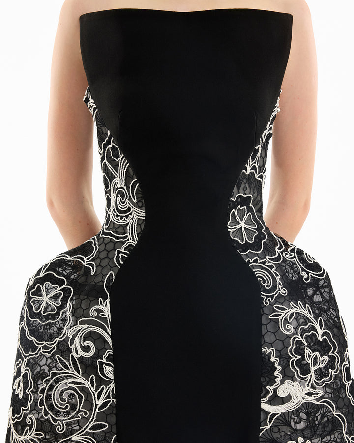 Black strapless dress with white floral lace details on a white background