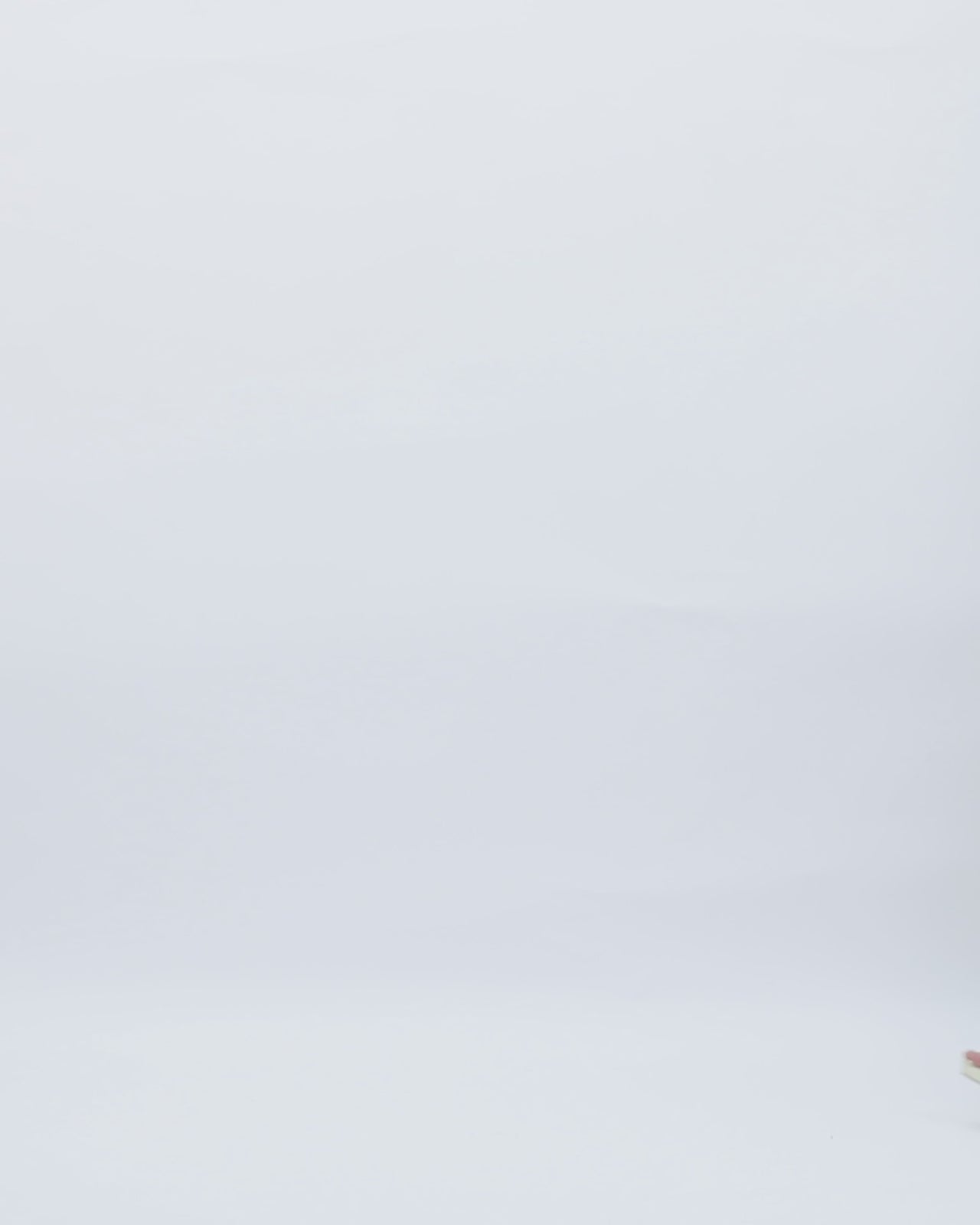 A long blush evening dress featuring a stone embellished collar, draping on the waist, a cut-out at the back, and a slit on the side.