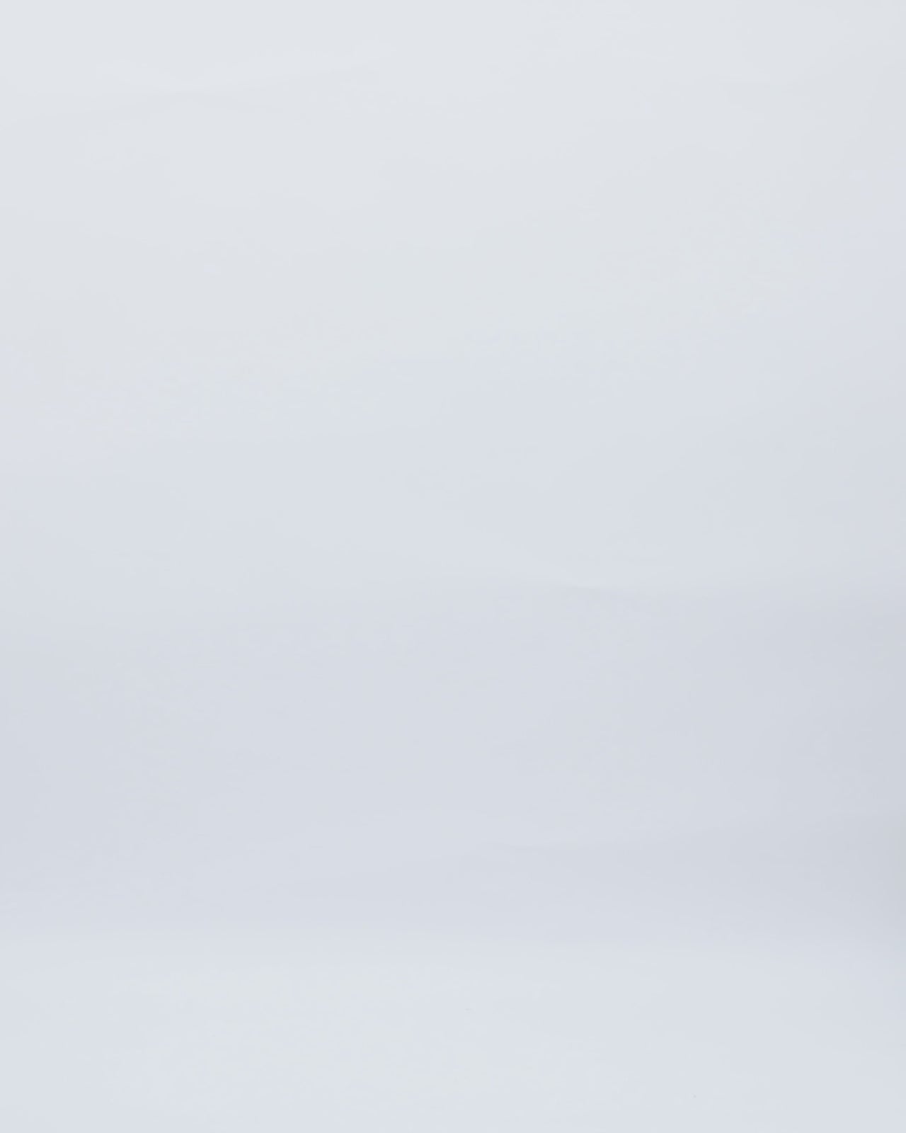 A strapless evening dress with a stone embellished corset and draped skirt, paired with a detachable bolero featuring draped sleeves and an embellished collar.