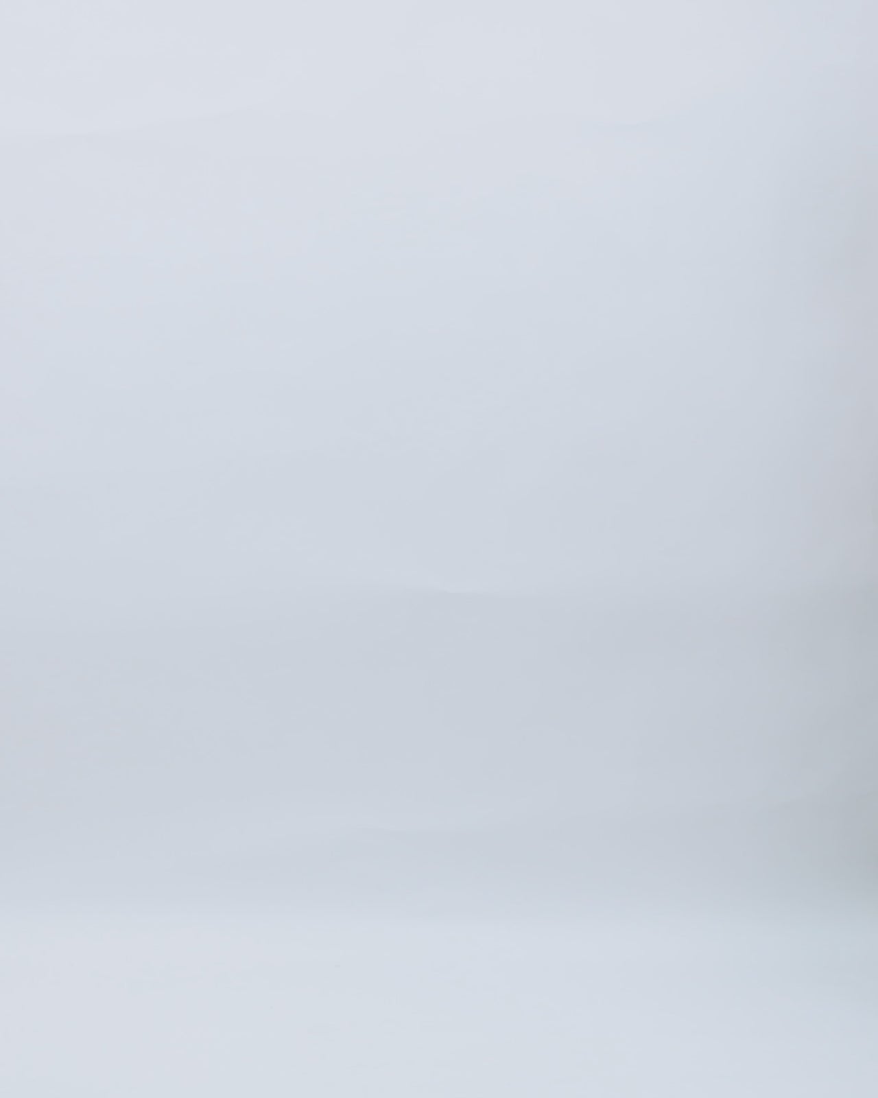 A one-shoulder black evening dress with draping and a slit on one side, and embroidery on the other.