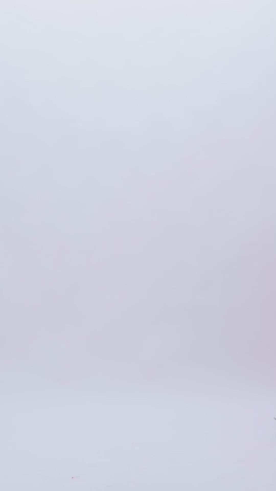 A loose-cut pink evening dress with draping at the waist and a slit on the side.