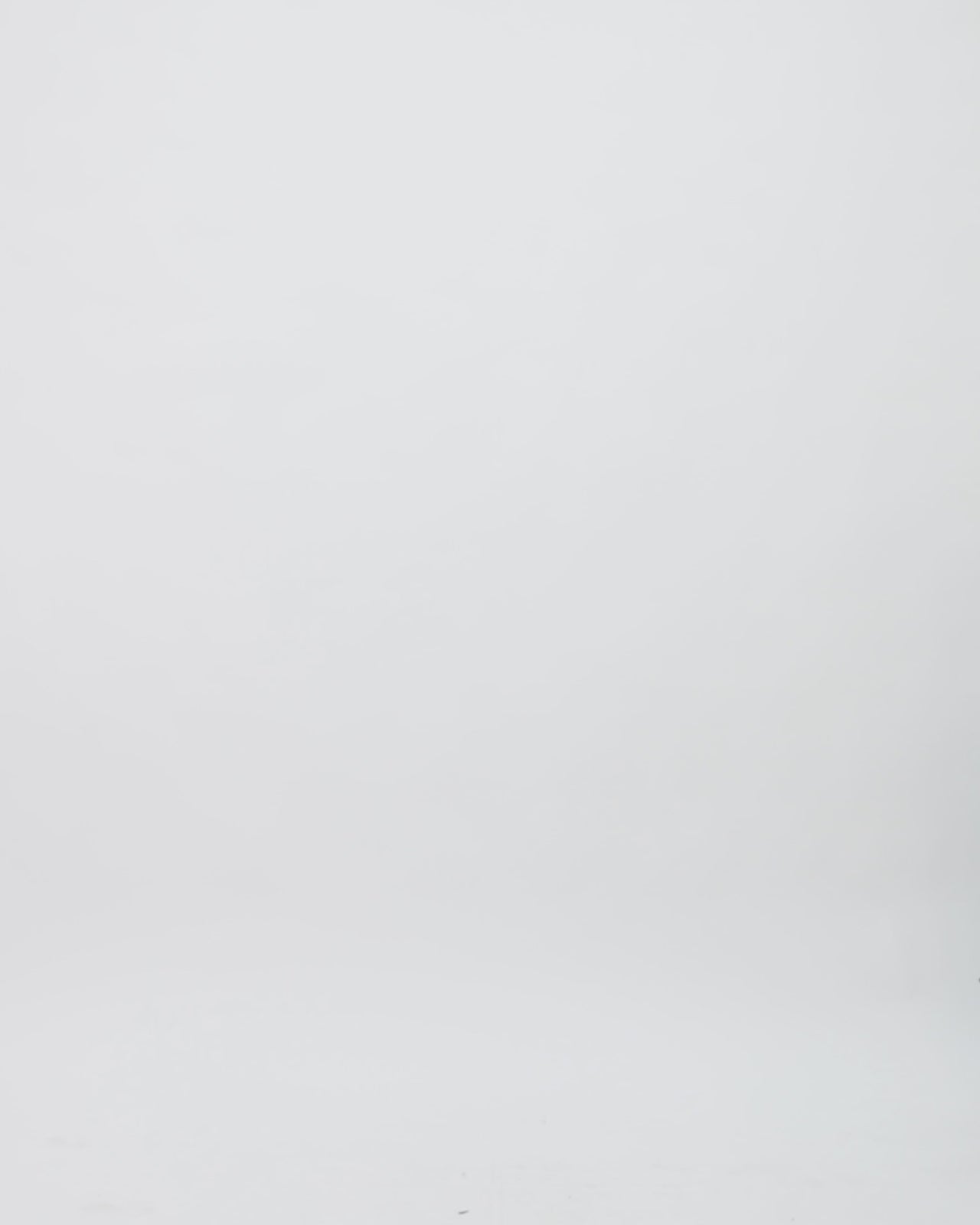 A V-neckline black dotted white tulle evening dress with a flowy structured skirt and a draped flower at the waist.