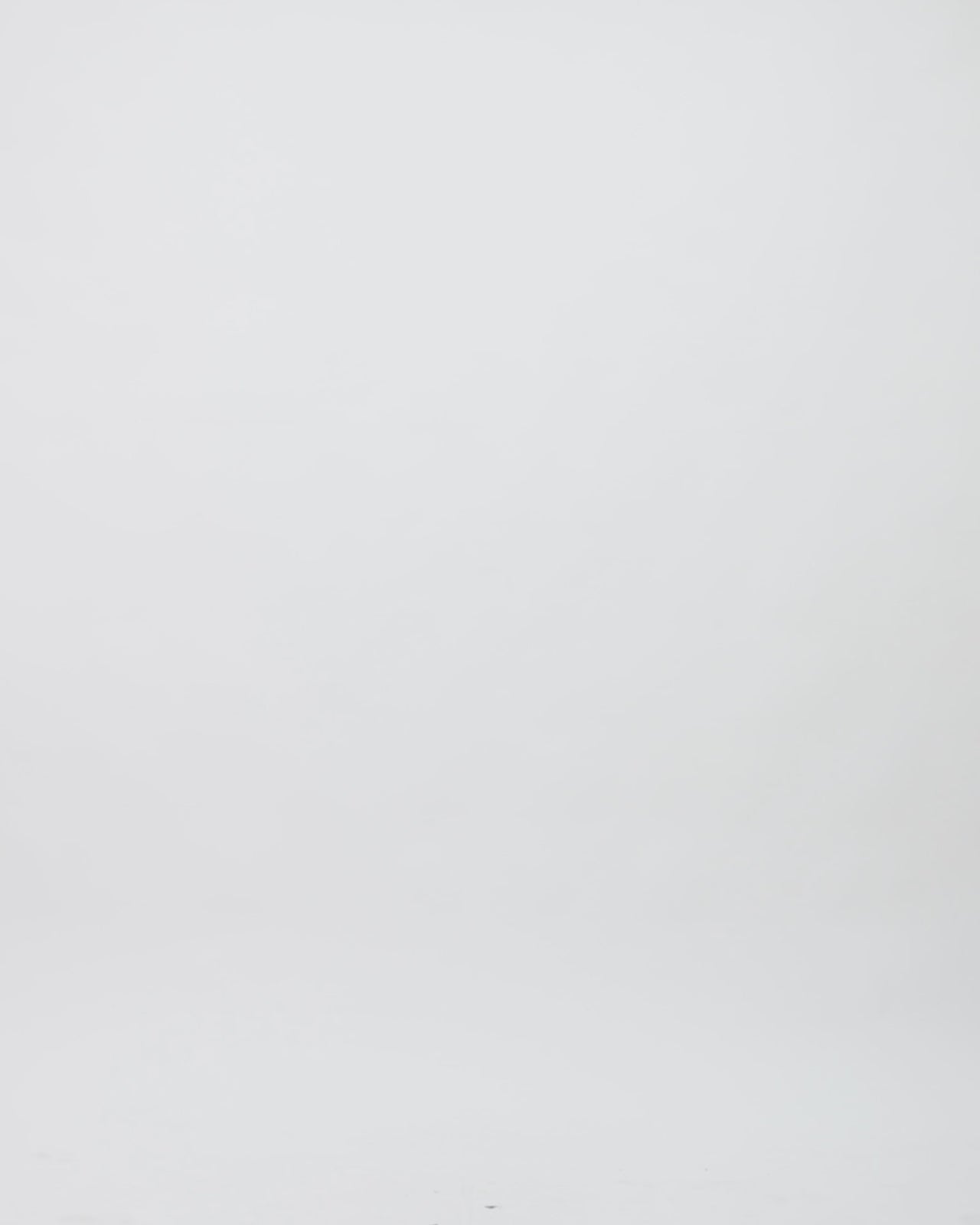 A V-neckline silver evening dress in net tulle with beading details on the side and a long draped cape-like one sleeve.