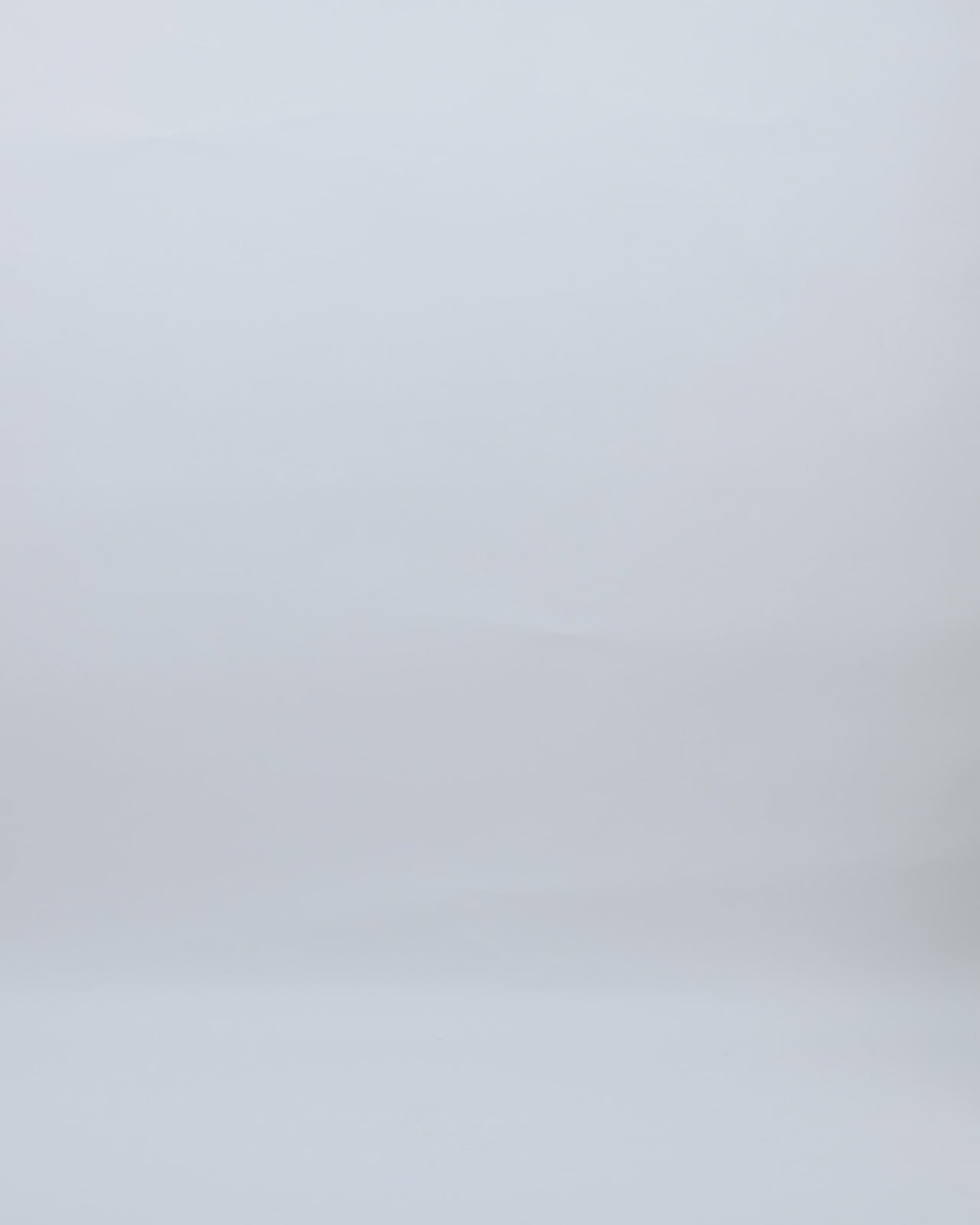 A V-neckline evening dress in cream tulle with bows on the shoulders, a draped waistline, and a V-cut back.