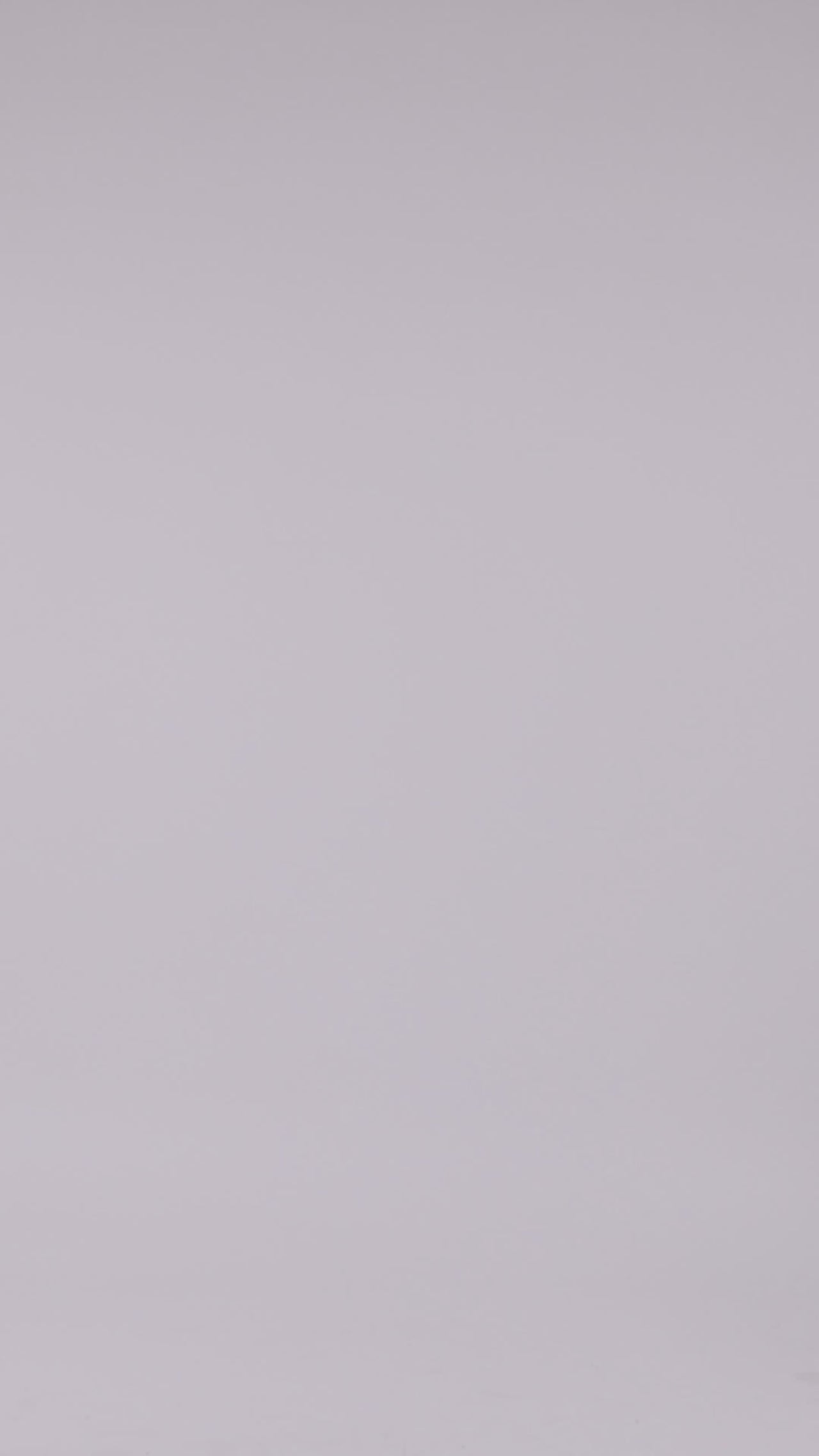 An asymmetrical off shoulders neckline long grey evening dress with draping details and a high slit on the side.