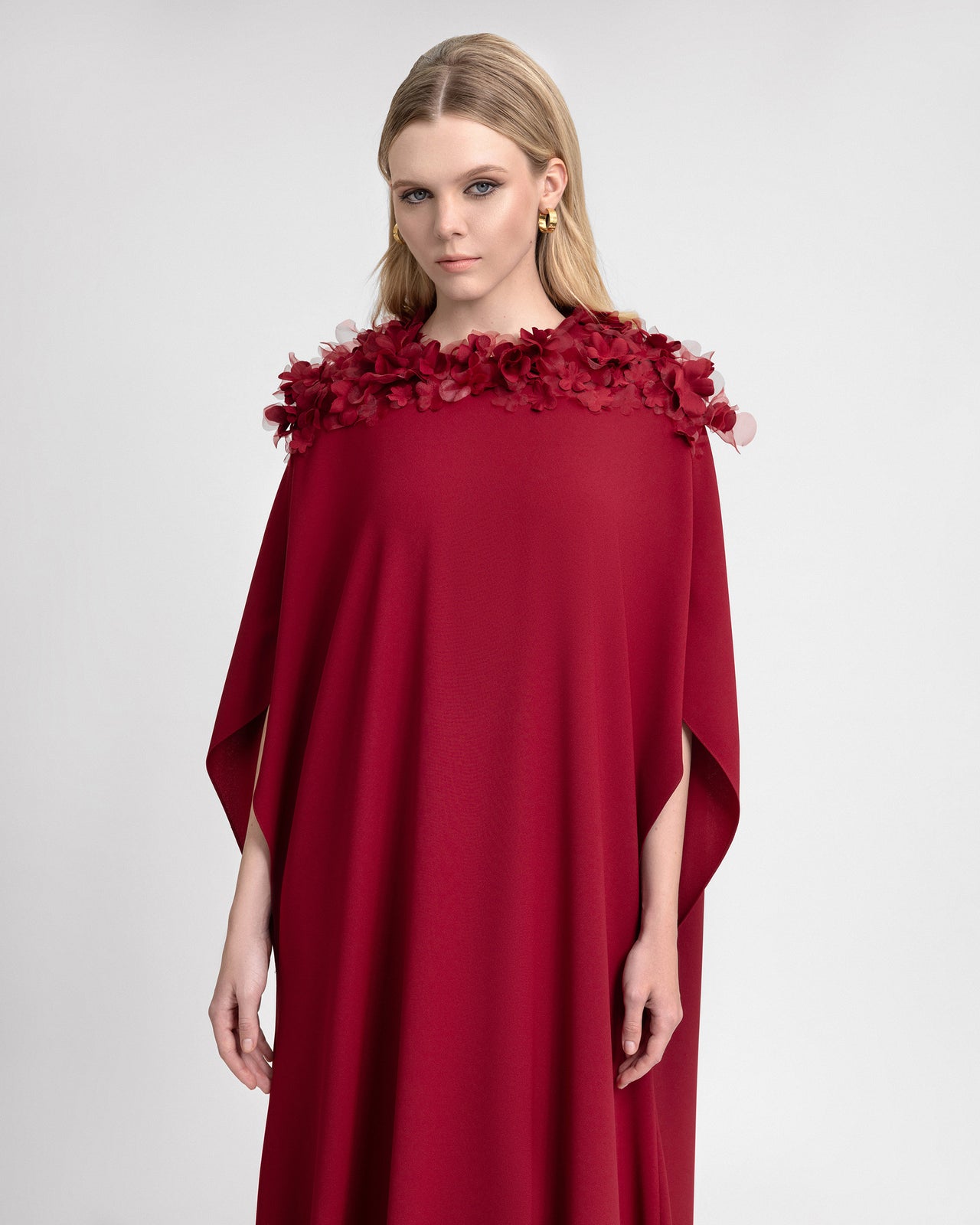 Video of a model wearing a loose-cut crepe and organza kaftan with three-quarter sleeves and a neckline adorned with 3D floral embellishments. As the model moves, the lightweight fabric flows gracefully, emphasizing the dress’s modest elegance and intricate floral detailing.