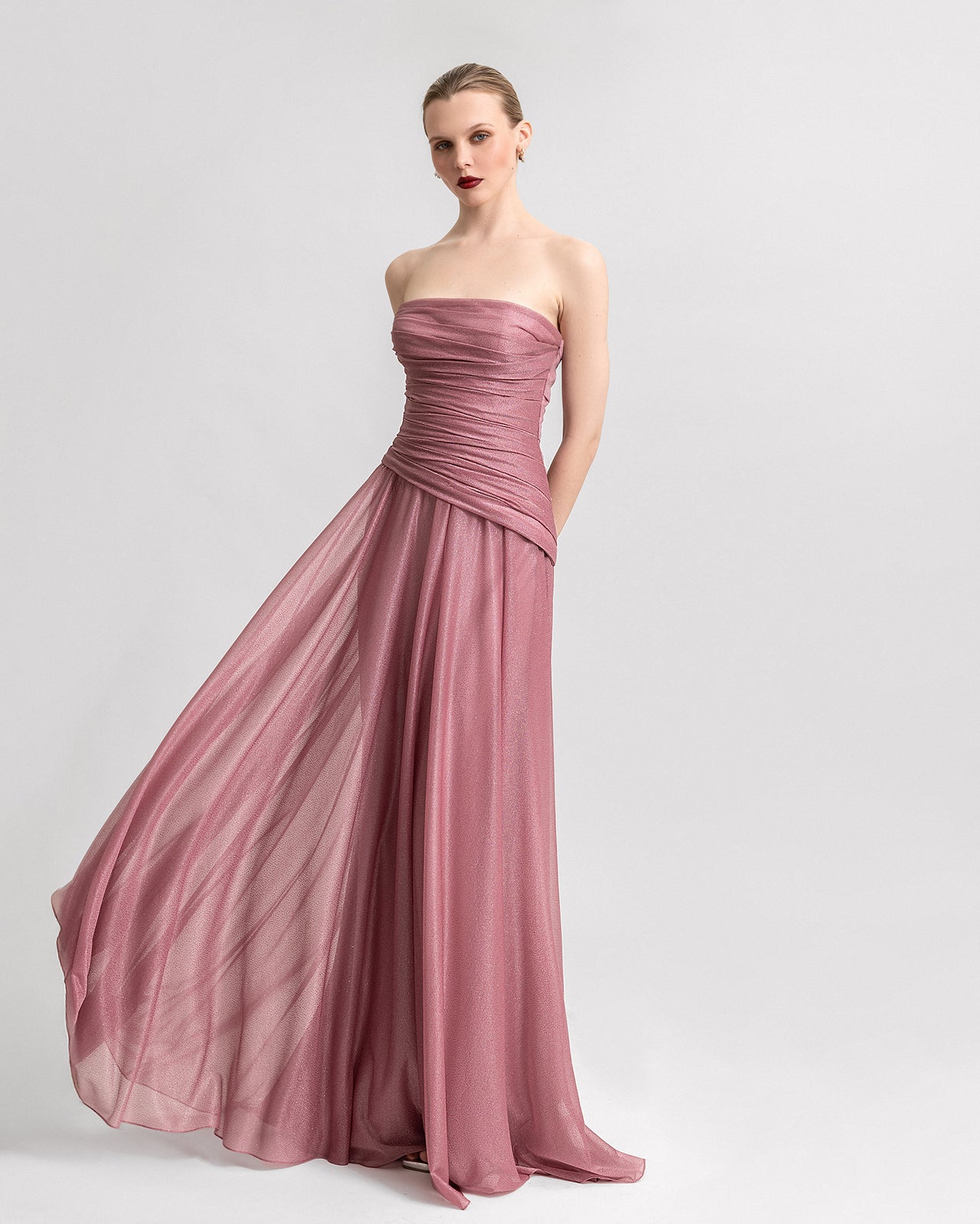 Video of a strapless pink shimmer dress with a ruched bodice and flowing skirt, shown from various angles to highlight the fit and movement.