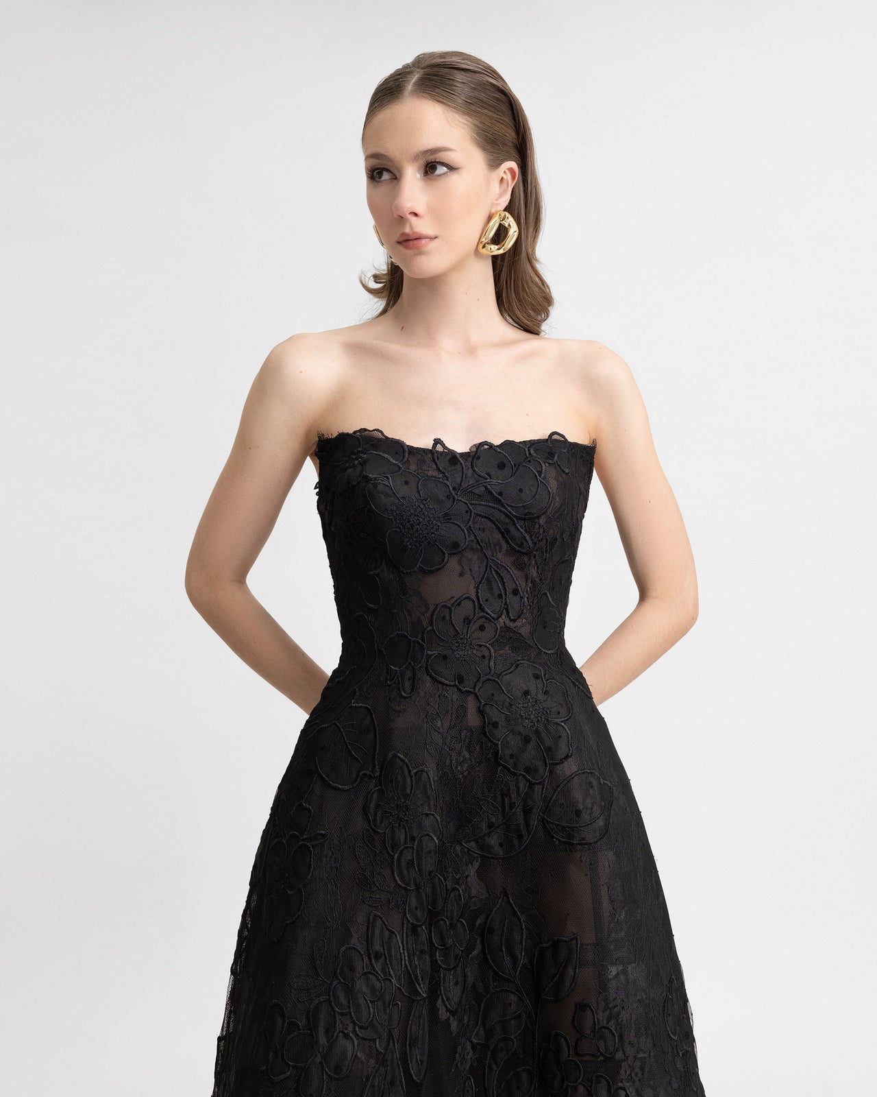 Video of a strapless black embroidered lace gown with a full cage skirt, shown without gloves. The styling focuses on the gown’s floral embroidery and sheer textures, offering a minimalist and elegant silhouette.
