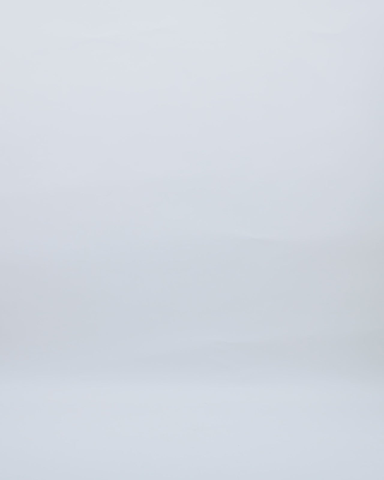 A long evening dress in cream color crepe with a draped corset, cowl neckline, bows on the shoulders and an open slit on the side.