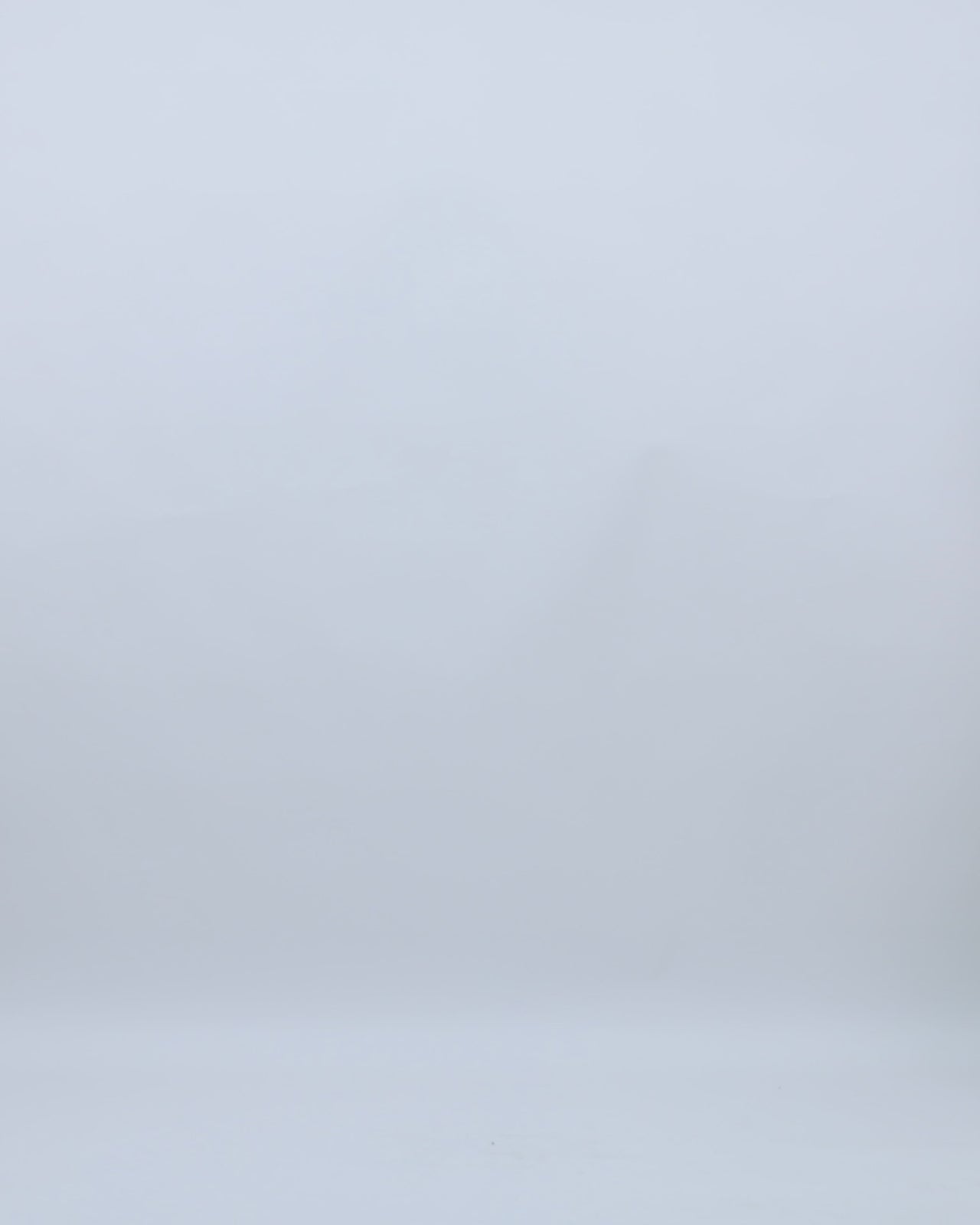 A one-shoulder draped chiffon irisé dress in ivory with a slit on the side.